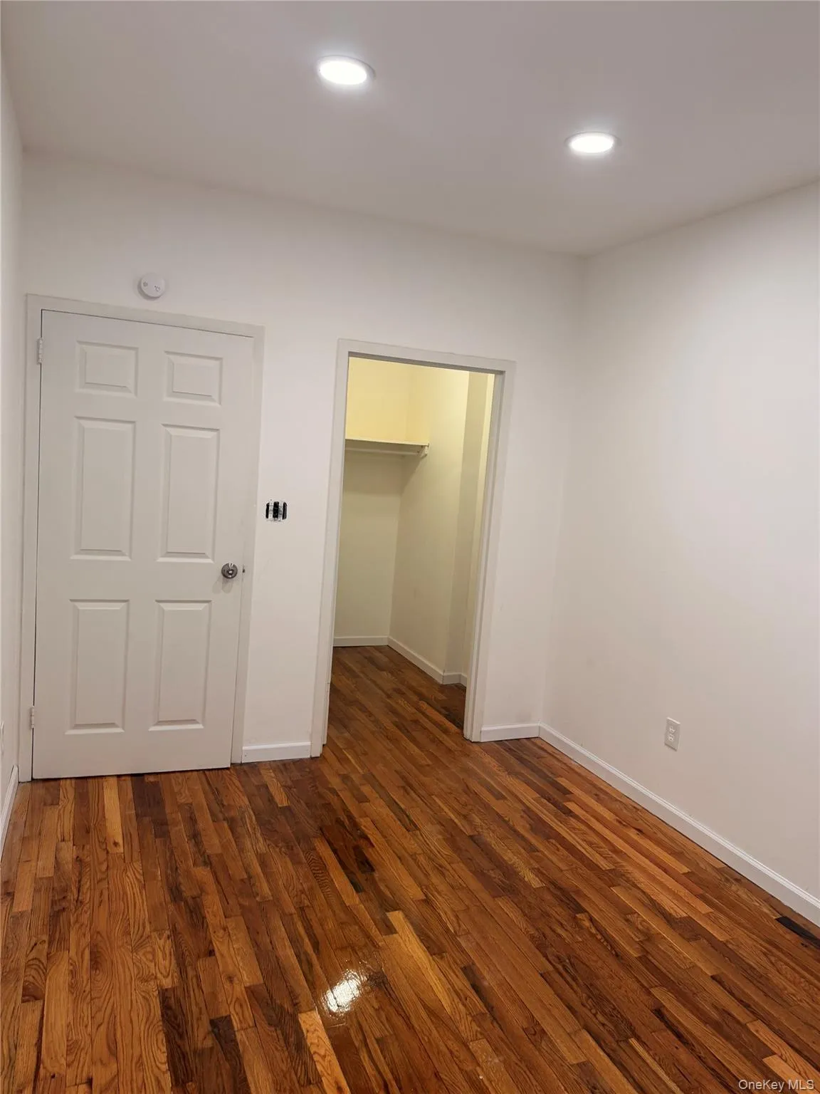 Unfurnished bedroom featuring dark wood-style floors, a spacious closet, and recessed lighting Unfurnished bedroom featuring dark wood-style floors, a spacious closet, and recessed lighting
