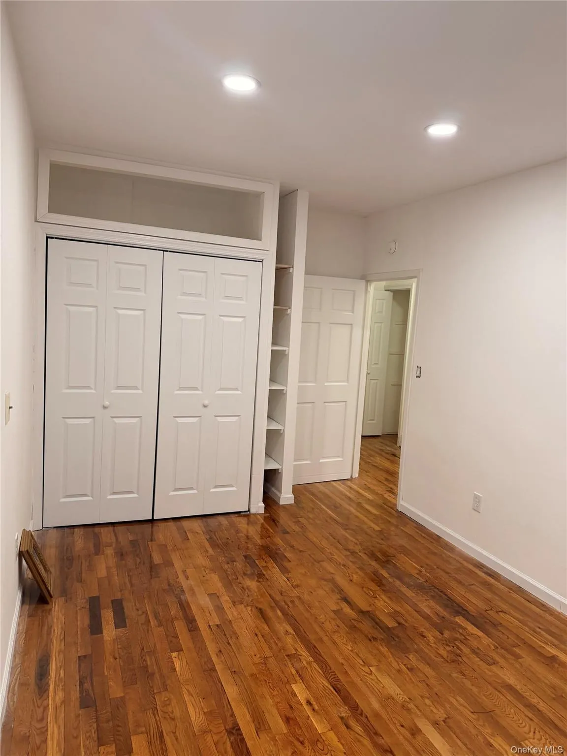 Unfurnished bedroom featuring dark wood-style flooring, a closet, and recessed lighting Unfurnished bedroom featuring dark wood-style flooring, a closet, and recessed lighting