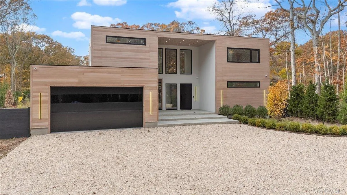 Contemporary home featuring gravel driveway and a garage
