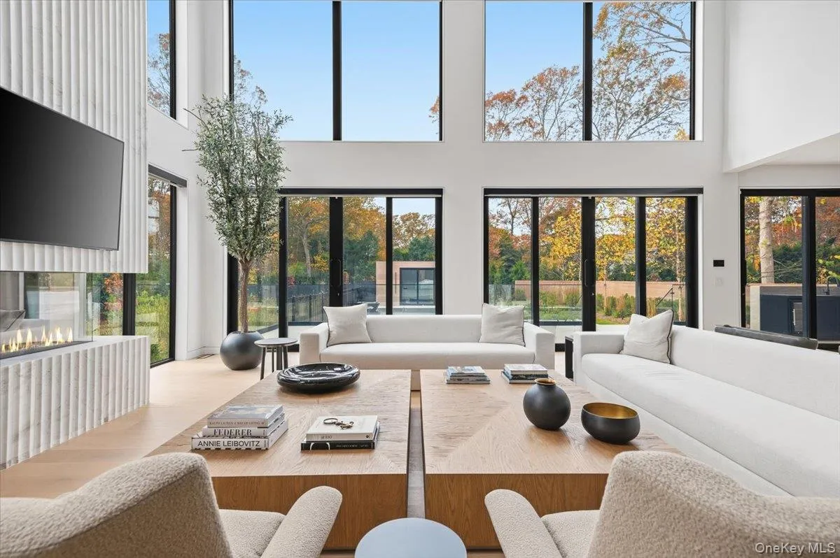 Living area featuring a towering ceiling, plenty of natural light, and wood finished floors
