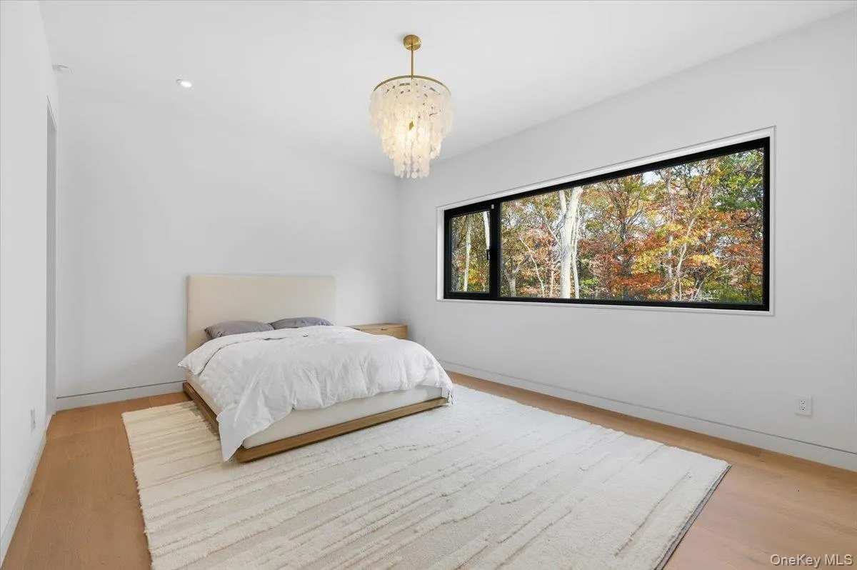 Bedroom with light wood finished floors, recessed lighting, and a chandelier