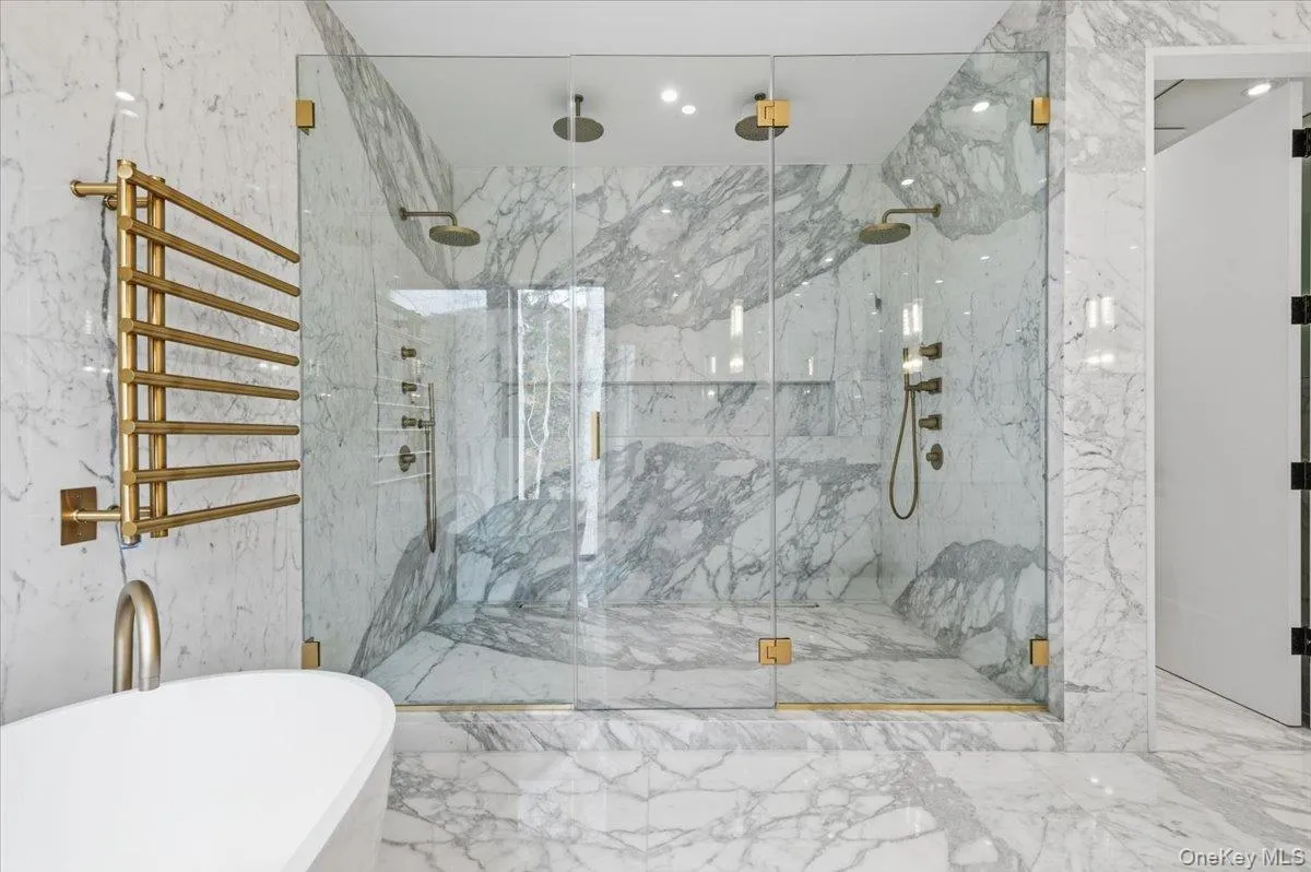 Full bathroom with stone wall, marble tiled flooring, a soaking tub, tile walls, and recessed lighting