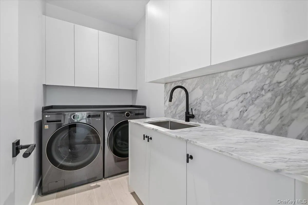 Washroom with washing machine and clothes dryer and cabinet space