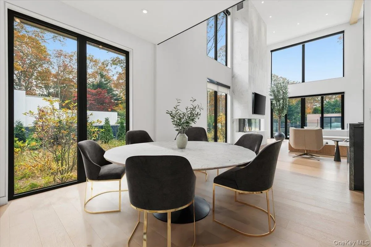 Dining space with a high ceiling, light wood finished floors, and recessed lighting