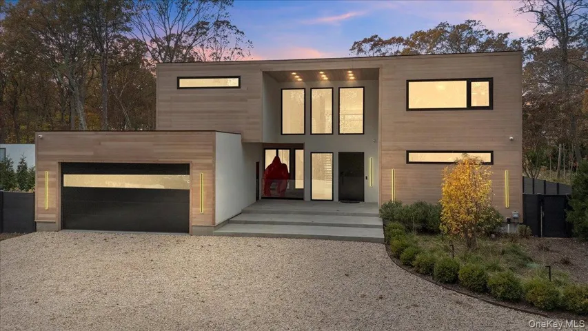 Contemporary home featuring gravel driveway and an attached garage