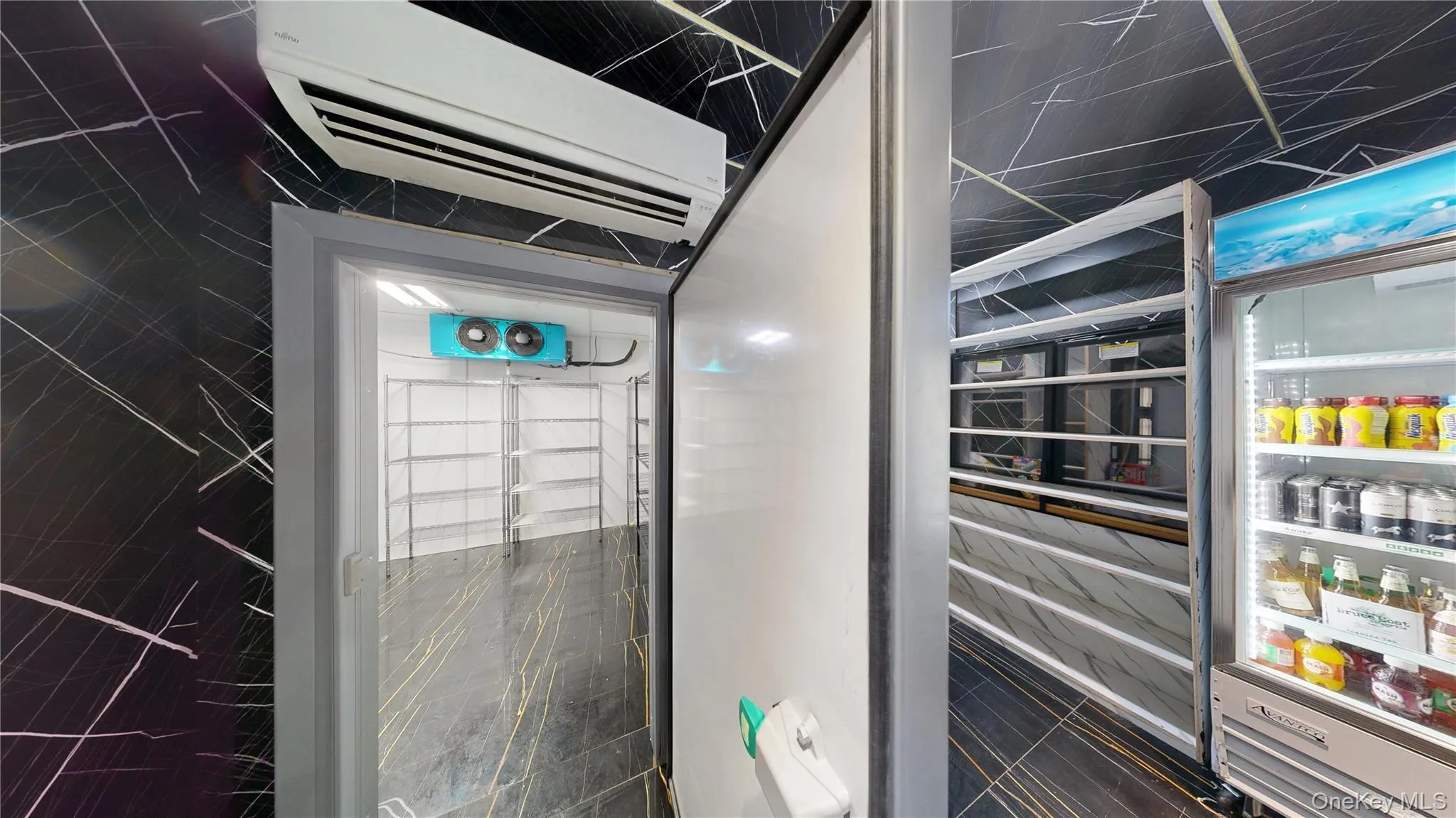 Bathroom view of a wall unit AC, a marble finish shower, and tile walls Bathroom view of a wall unit AC, a marble finish shower, and tile walls