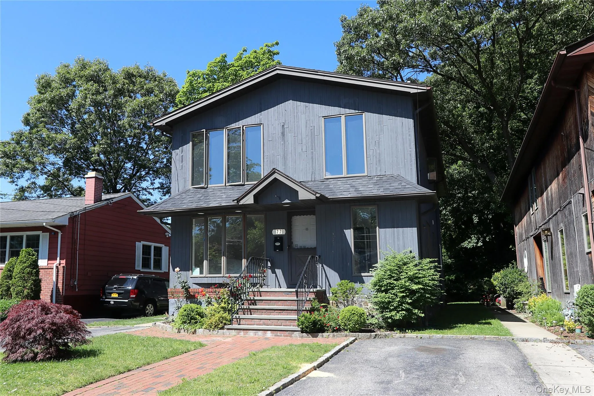 View of front facade with roof with shingles and a front yard View of front facade with roof with shingles and a front yard