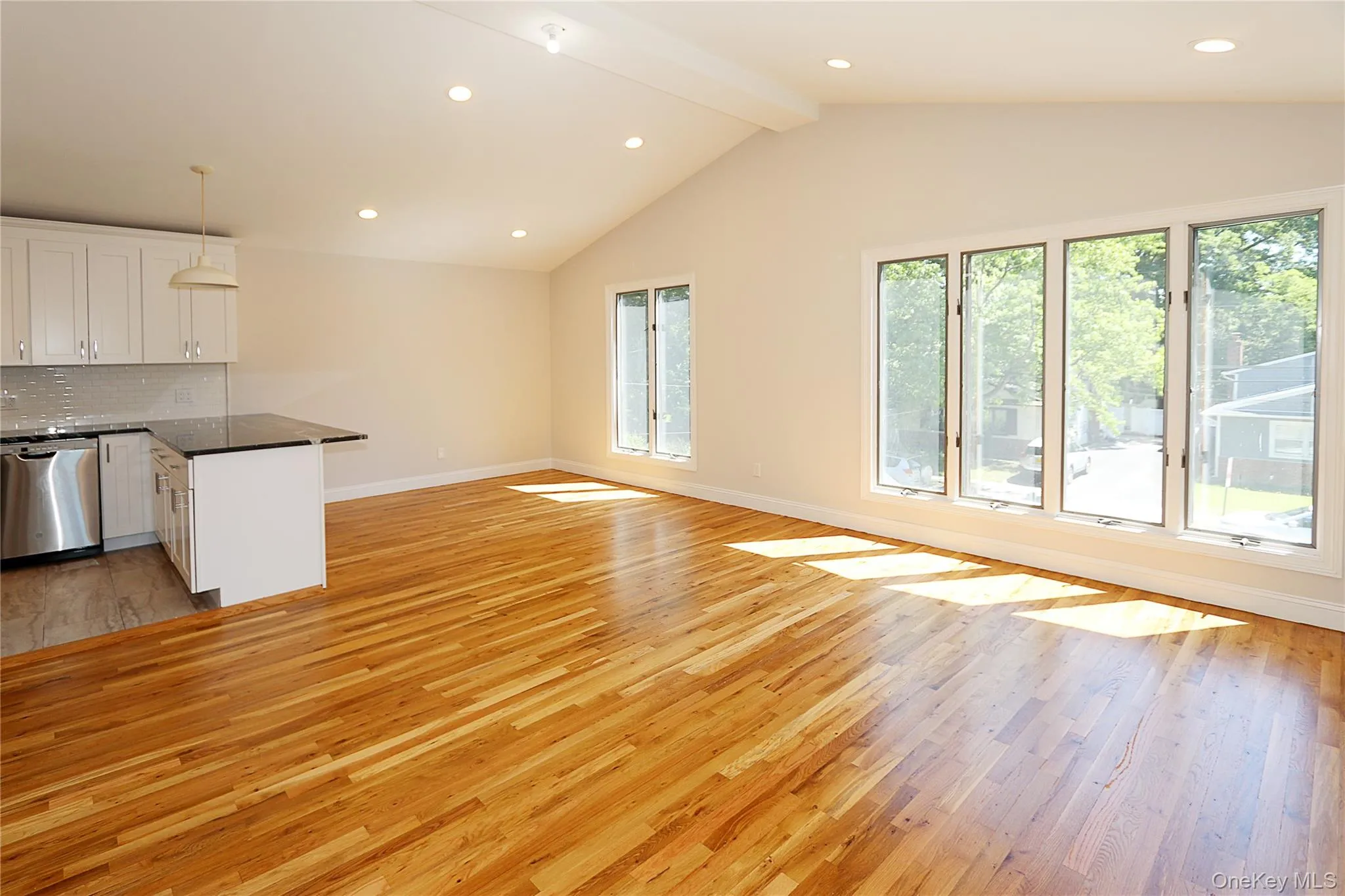 Kitchen featuring light wood-type flooring, recessed lighting, open floor plan, hanging light fixtures, and backsplash Kitchen featuring light wood-type flooring, recessed lighting, open floor plan, hanging light fixtures, and backsplash