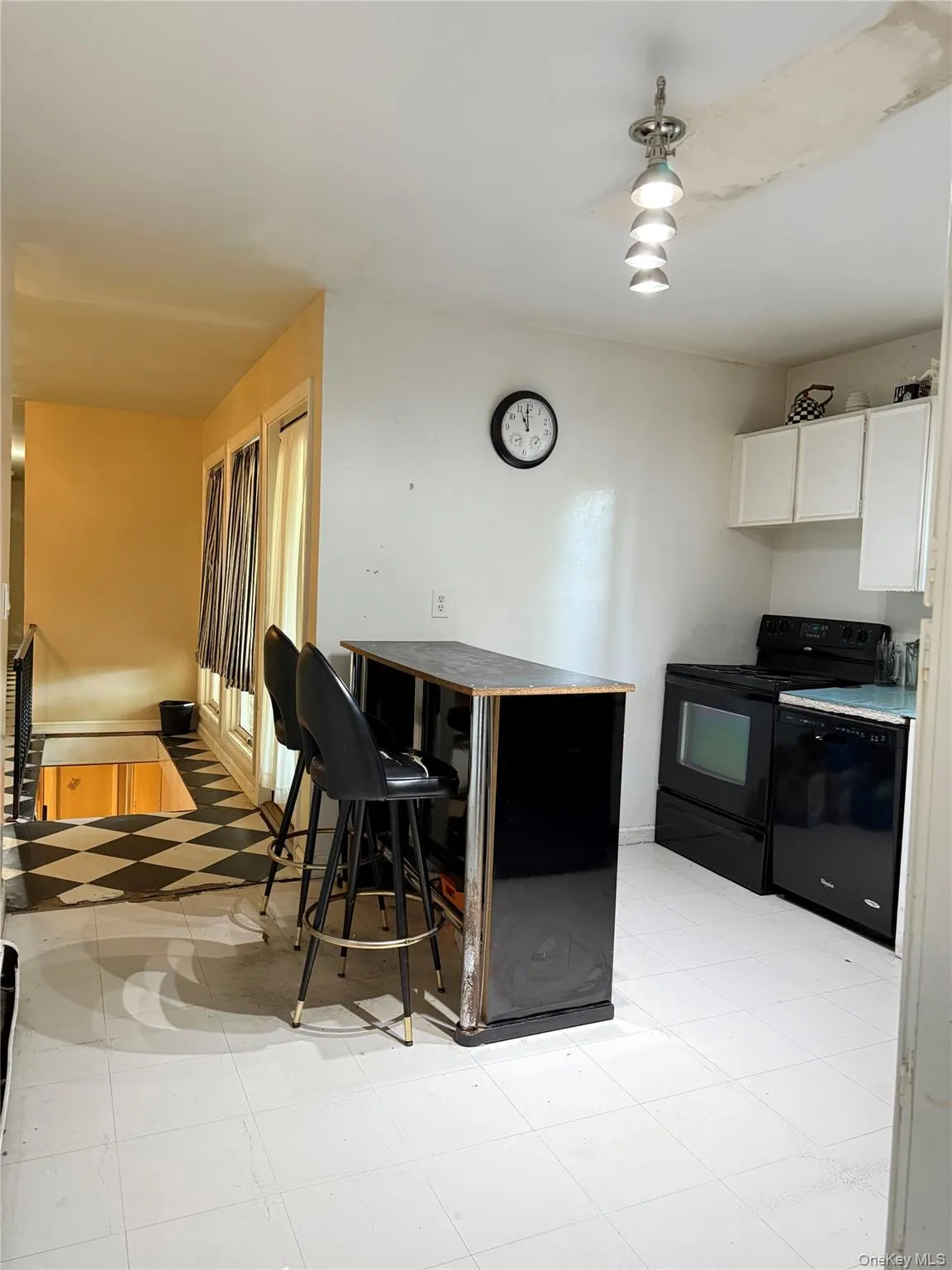 Kitchen with black appliances, white cabinetry, and dark countertops Kitchen with black appliances, white cabinetry, and dark countertops