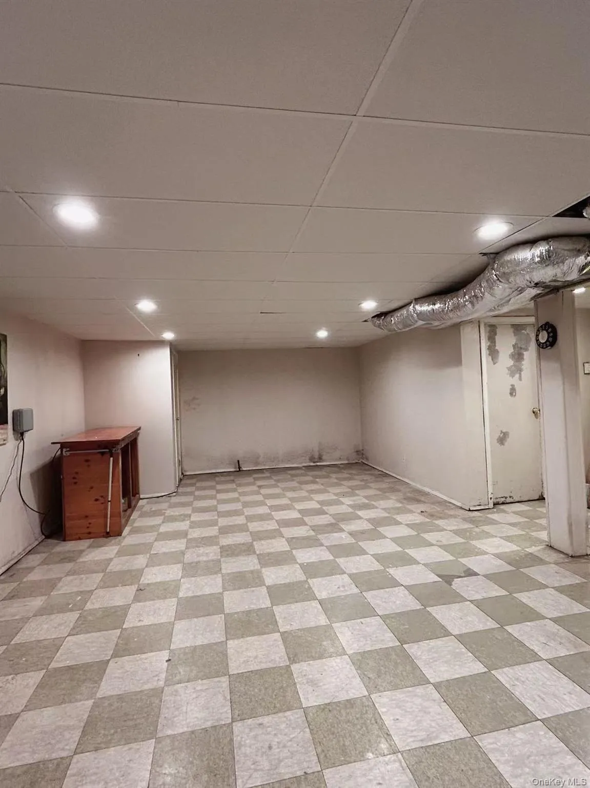 Finished below grade area featuring light flooring, a drop ceiling, and recessed lighting Finished below grade area featuring light flooring, a drop ceiling, and recessed lighting