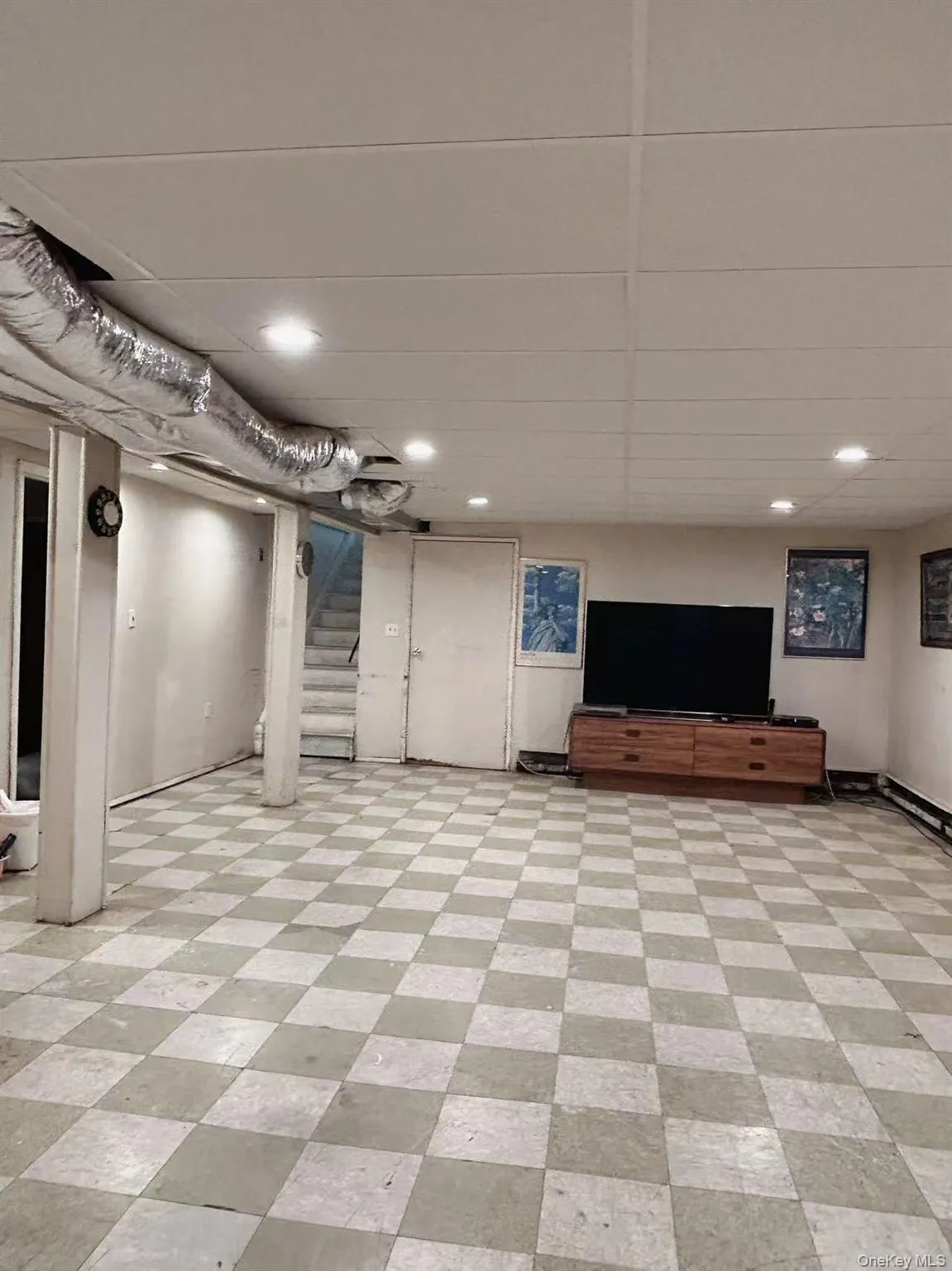 Finished below grade area with light floors, stairs, a drop ceiling, and recessed lighting Finished below grade area with light floors, stairs, a drop ceiling, and recessed lighting