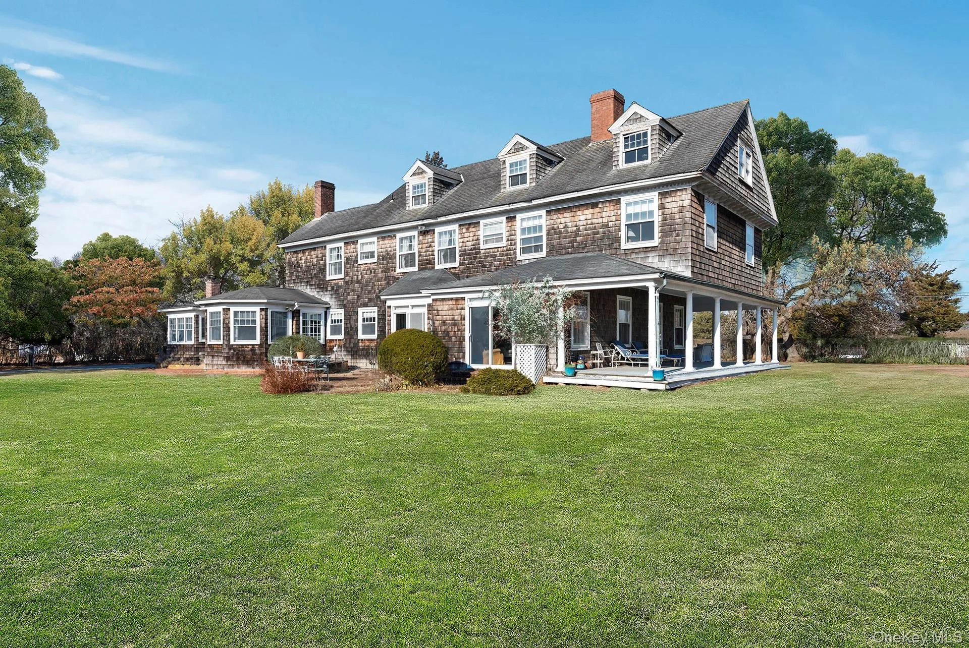 Rear view of property with expansive lawn, patio, and covered porch Rear view of property with expansive lawn, patio, and covered porch