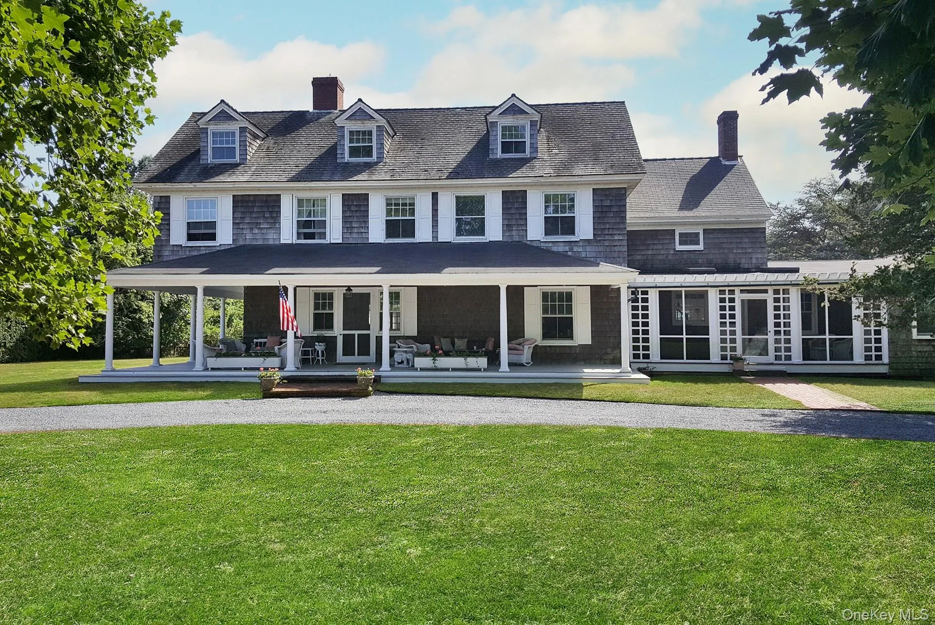 View of front facade with a covered porch, a sunroom/screened porch, and a front yard View of front facade with a covered porch, a sunroom/screened porch, and a front yard