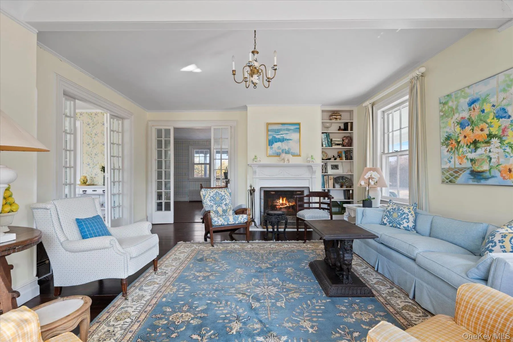 Living room with chandelier, crown molding, fireplace, and hardwood floors Living room with chandelier, crown molding, fireplace, and hardwood floors