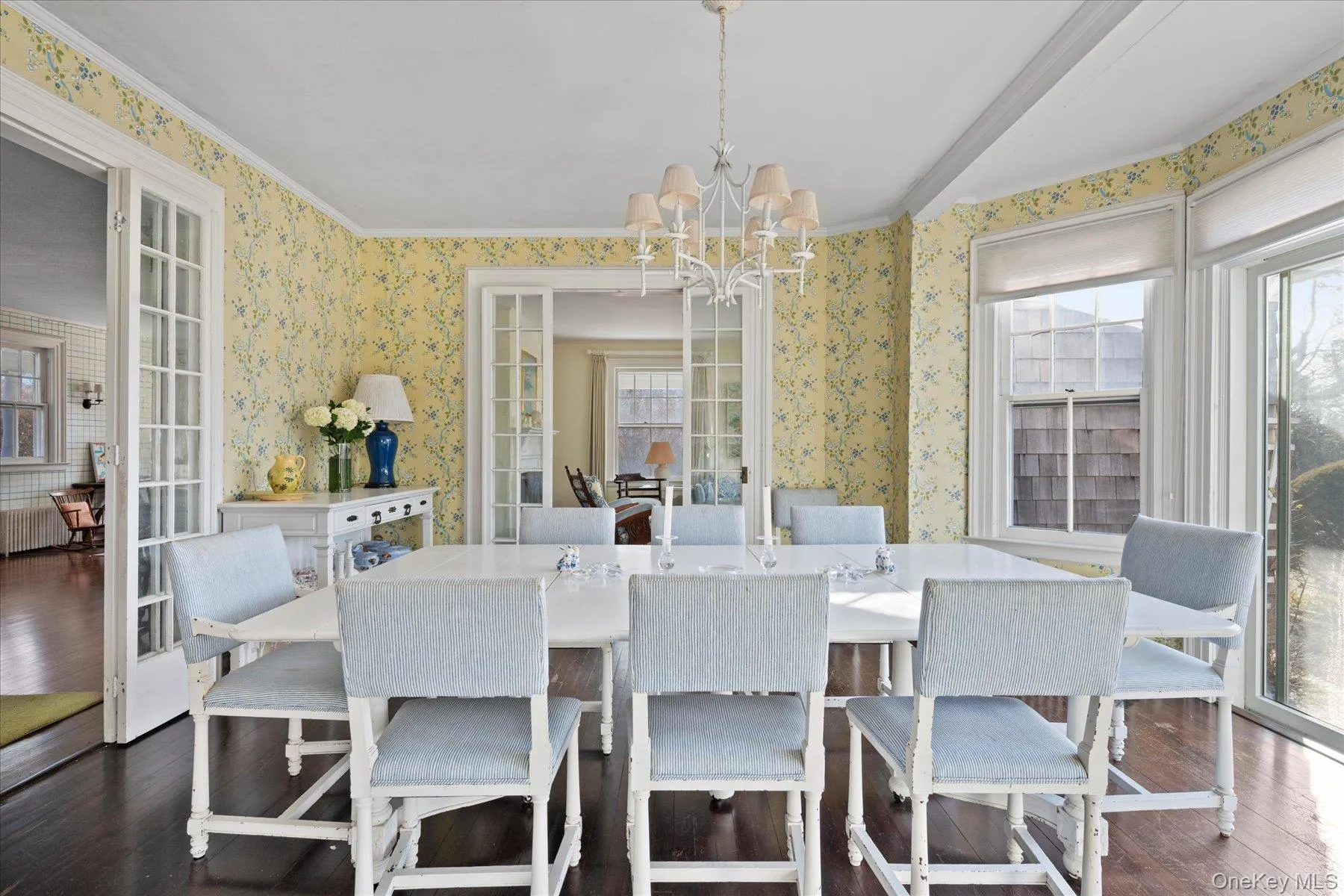 Dining room featuring an inviting chandelier, dark wood-type flooring, and french doors Dining room featuring an inviting chandelier, dark wood-type flooring, and french doors