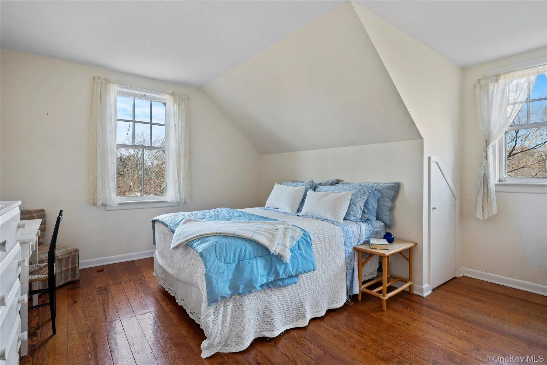 Guest Apt. Bedroom featuring dark hardwood flooring, multiple windows, and lofted ceiling Guest Apt. Bedroom featuring dark hardwood flooring, multiple windows, and lofted ceiling