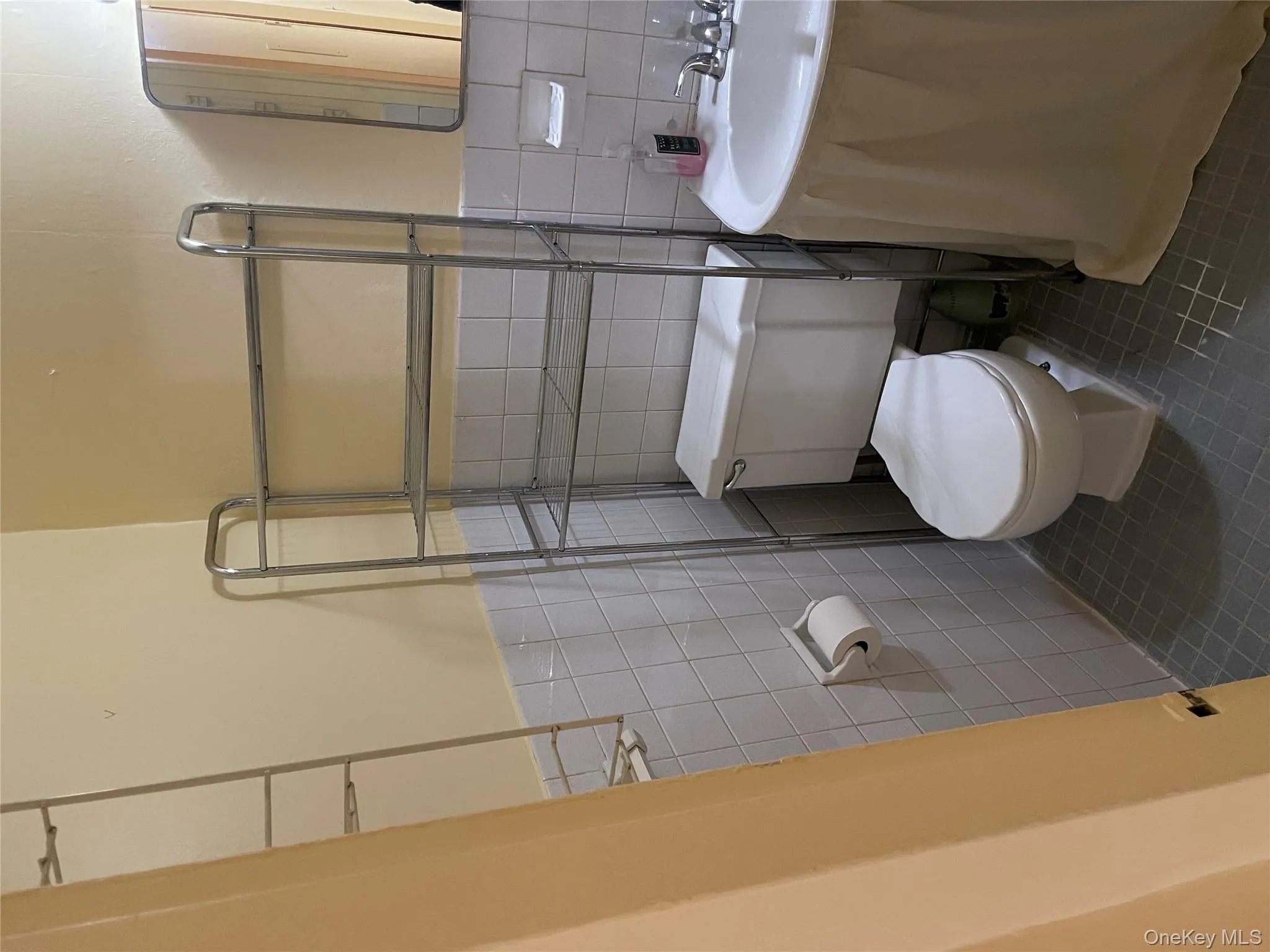 Half bath with dark tile patterned flooring and tile walls Half bath with dark tile patterned flooring and tile walls