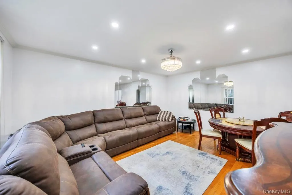 Living room featuring wood finished floors, ornamental molding, arched walkways, and recessed lighting Living room featuring wood finished floors, ornamental molding, arched walkways, and recessed lighting