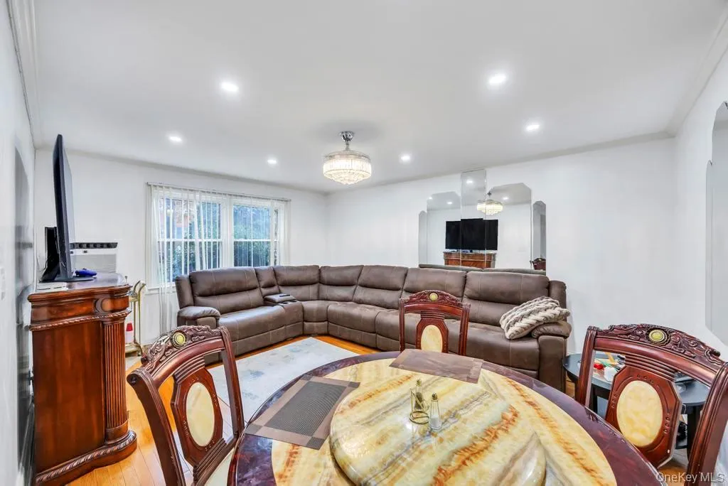 Living area featuring wood finished floors, recessed lighting, and crown molding Living area featuring wood finished floors, recessed lighting, and crown molding