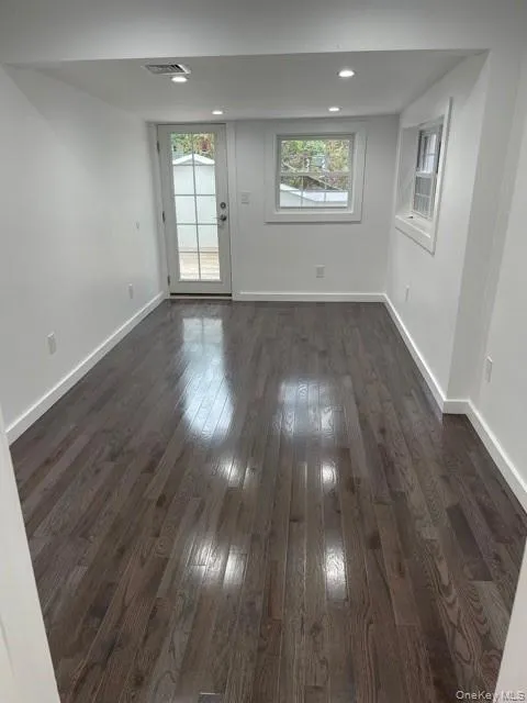 Bedroom with dark wood finished floors and recessed lighting access to the patio Bedroom with dark wood finished floors and recessed lighting access to the patio