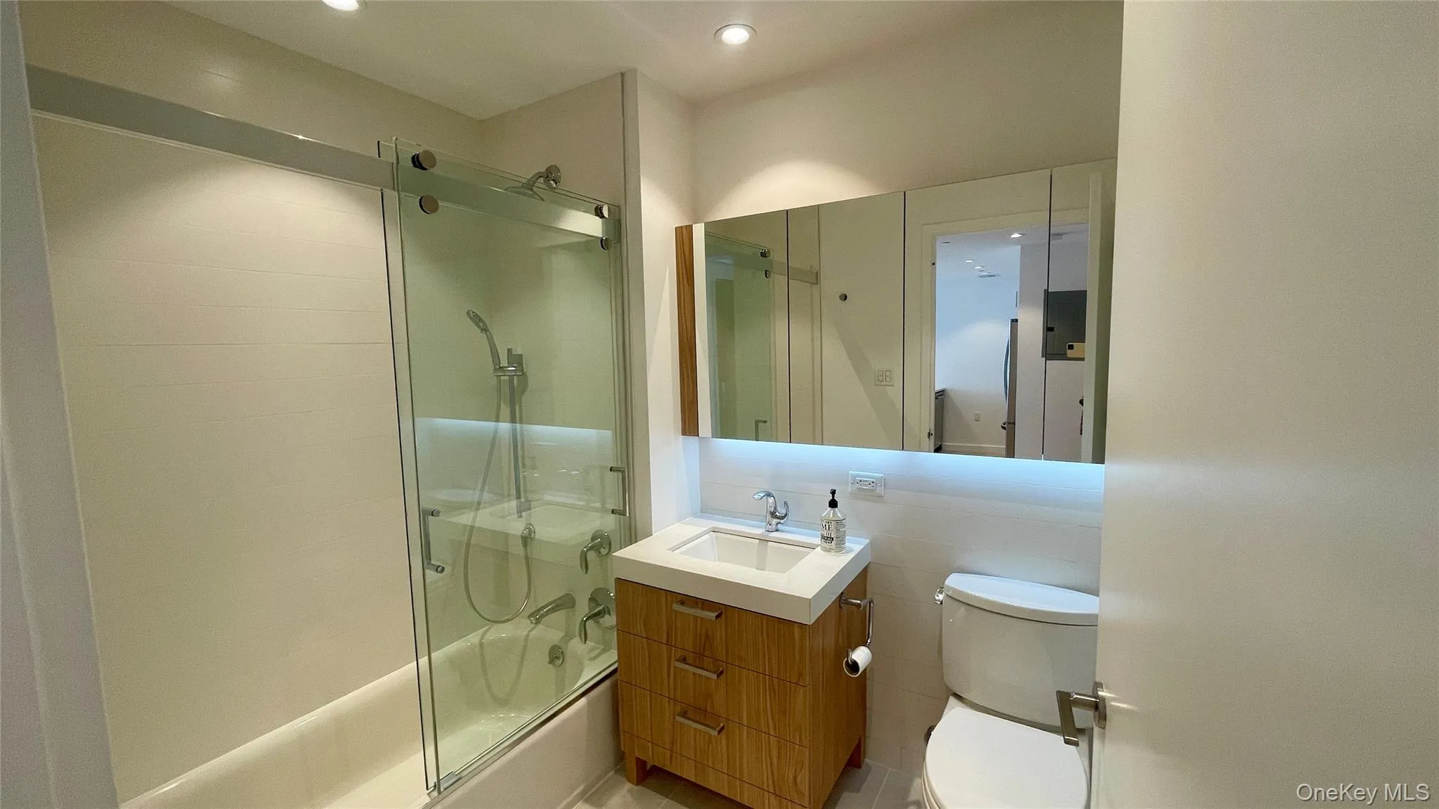 Full bath with vanity, bath / shower combo with glass door, and recessed lighting Full bath with vanity, bath / shower combo with glass door, and recessed lighting