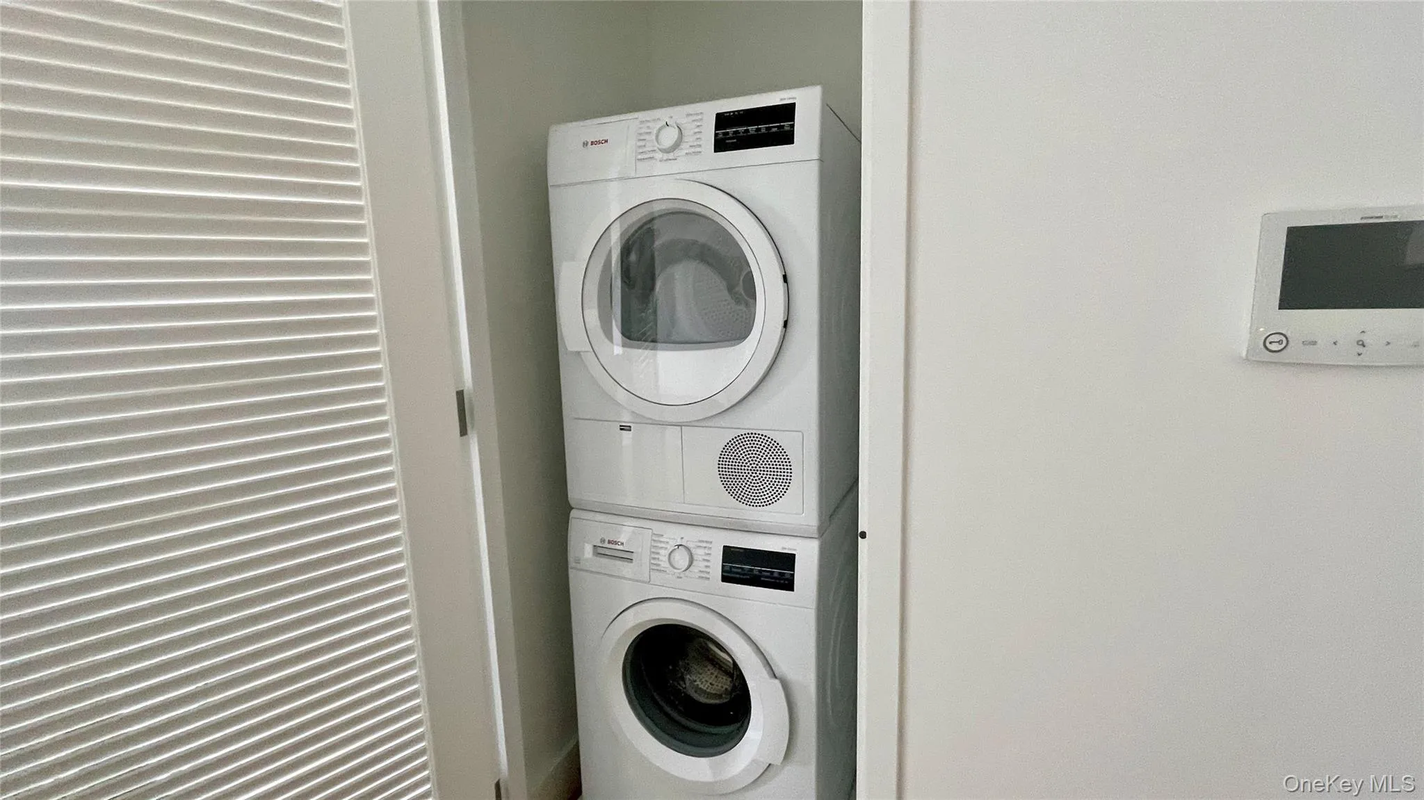 Laundry room featuring stacked washer / dryer Laundry room featuring stacked washer / dryer