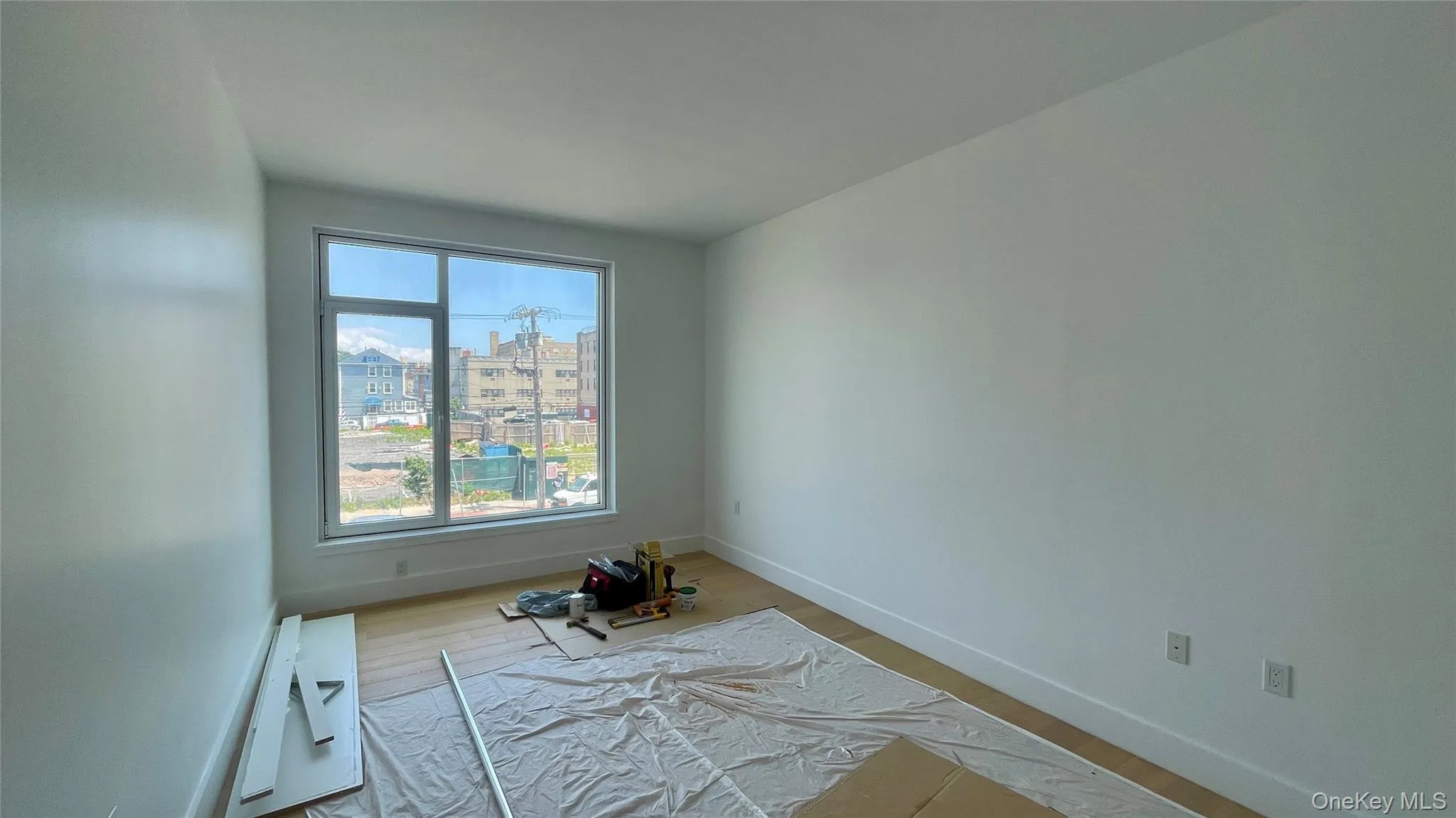 Unfurnished room with wood finished floors and a view of city Unfurnished room with wood finished floors and a view of city