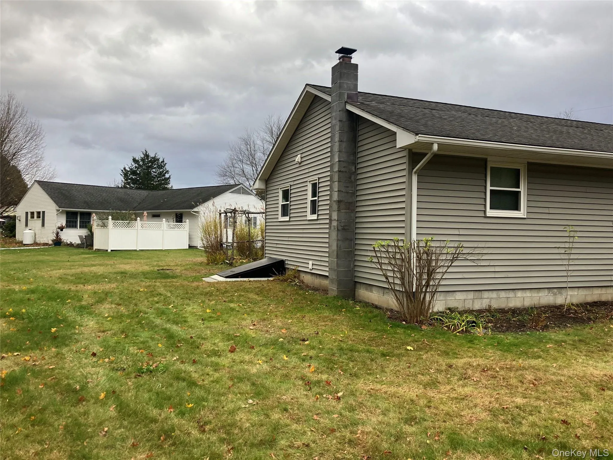 View of side of home featuring a yard and a chimney View of side of home featuring a yard and a chimney