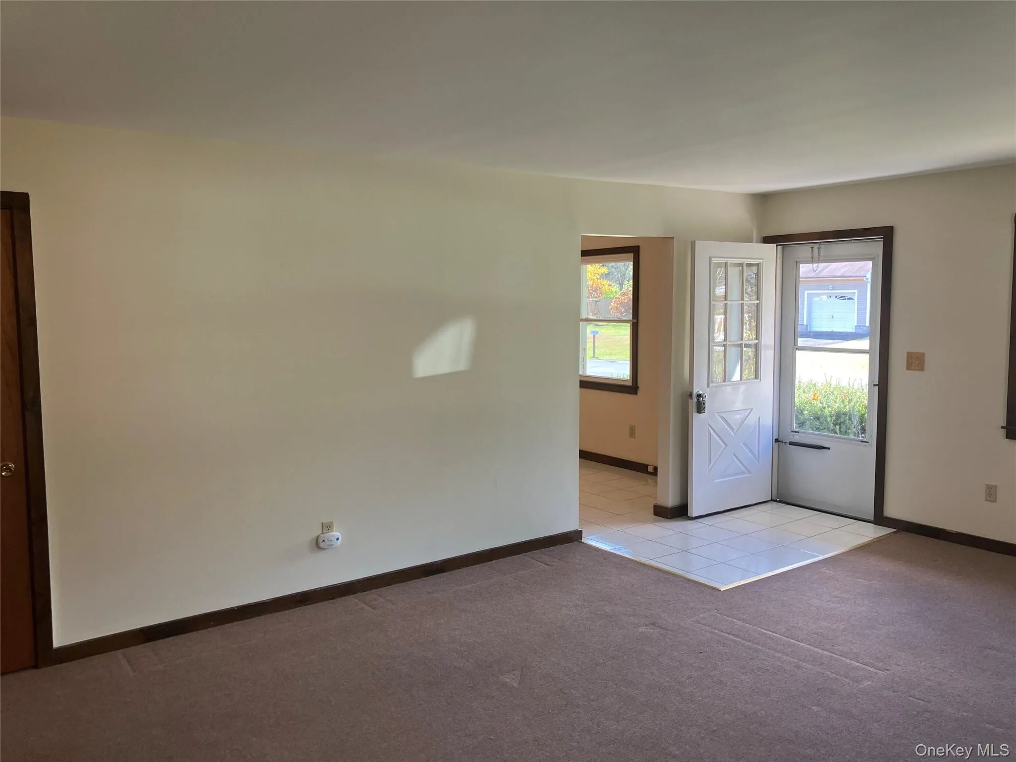Entrance foyer featuring light carpet and light tile patterned flooring Entrance foyer featuring light carpet and light tile patterned flooring