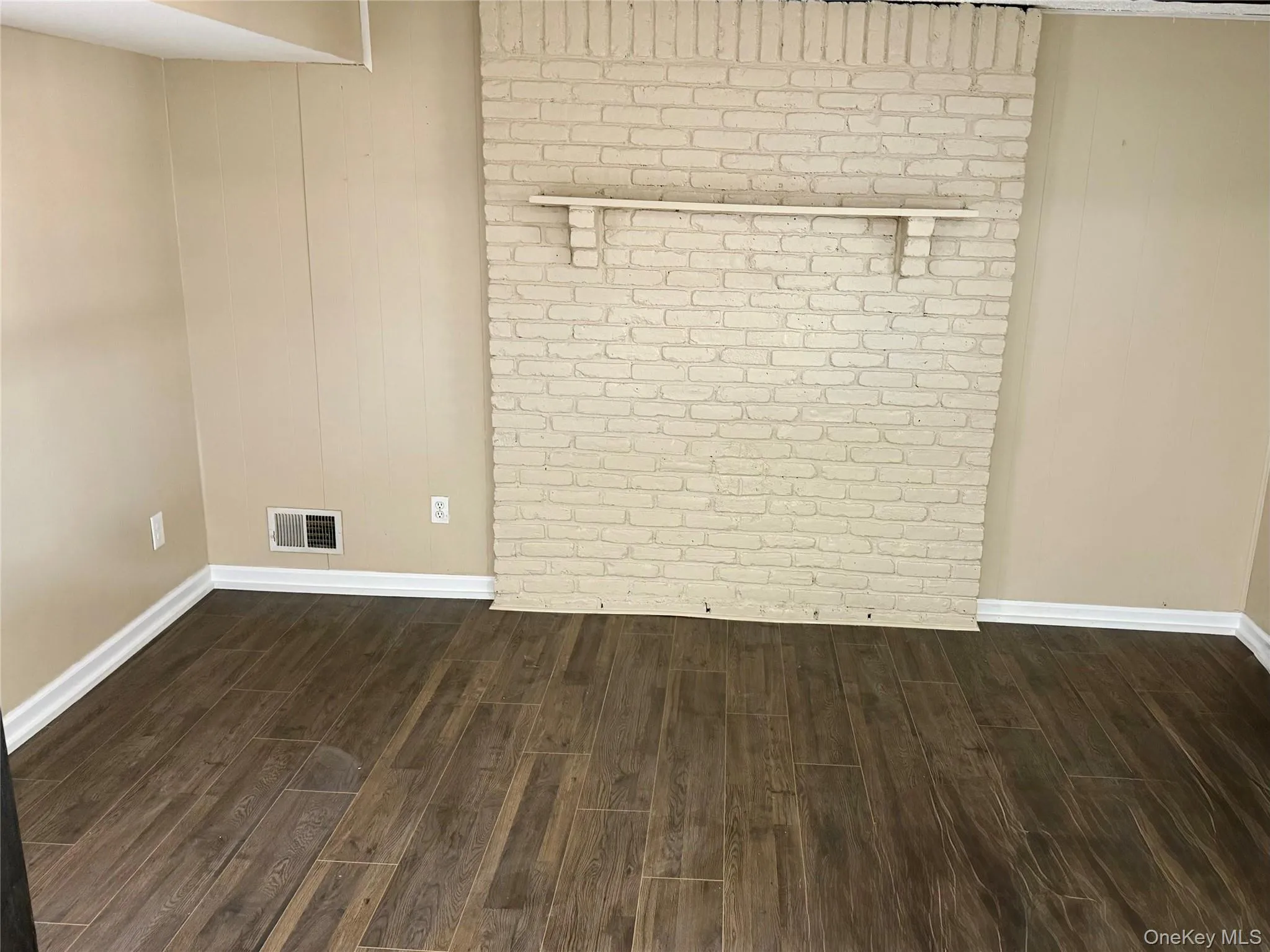 Spare room featuring dark wood-style floors and baseboards Spare room featuring dark wood-style floors and baseboards