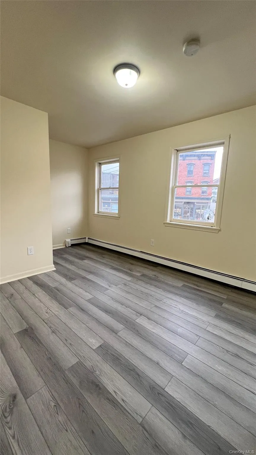 Bedroom 2 with baseboard heating and wood-style finished floors Bedroom 2 with baseboard heating and wood-style finished floors