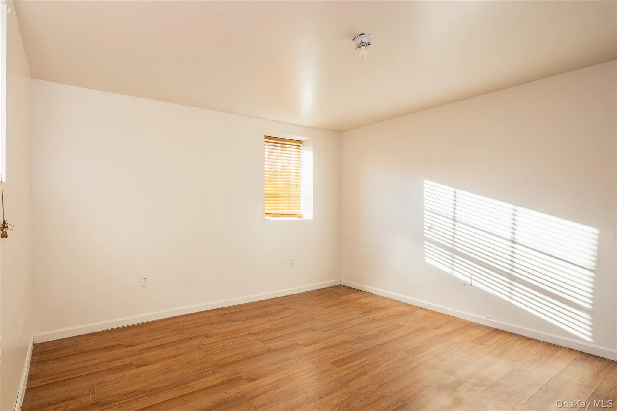 Unfurnished room with wood finished floors and baseboards Unfurnished room with wood finished floors and baseboards