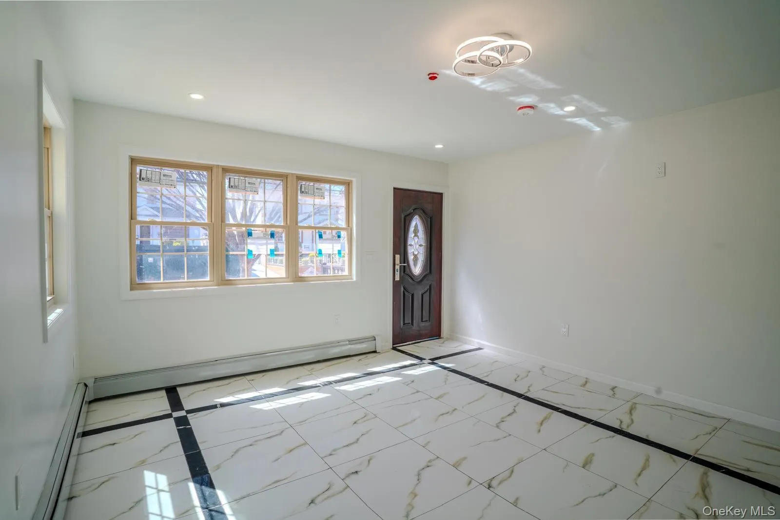 Foyer with marble finish flooring, baseboard heating, and recessed lighting Foyer with marble finish flooring, baseboard heating, and recessed lighting