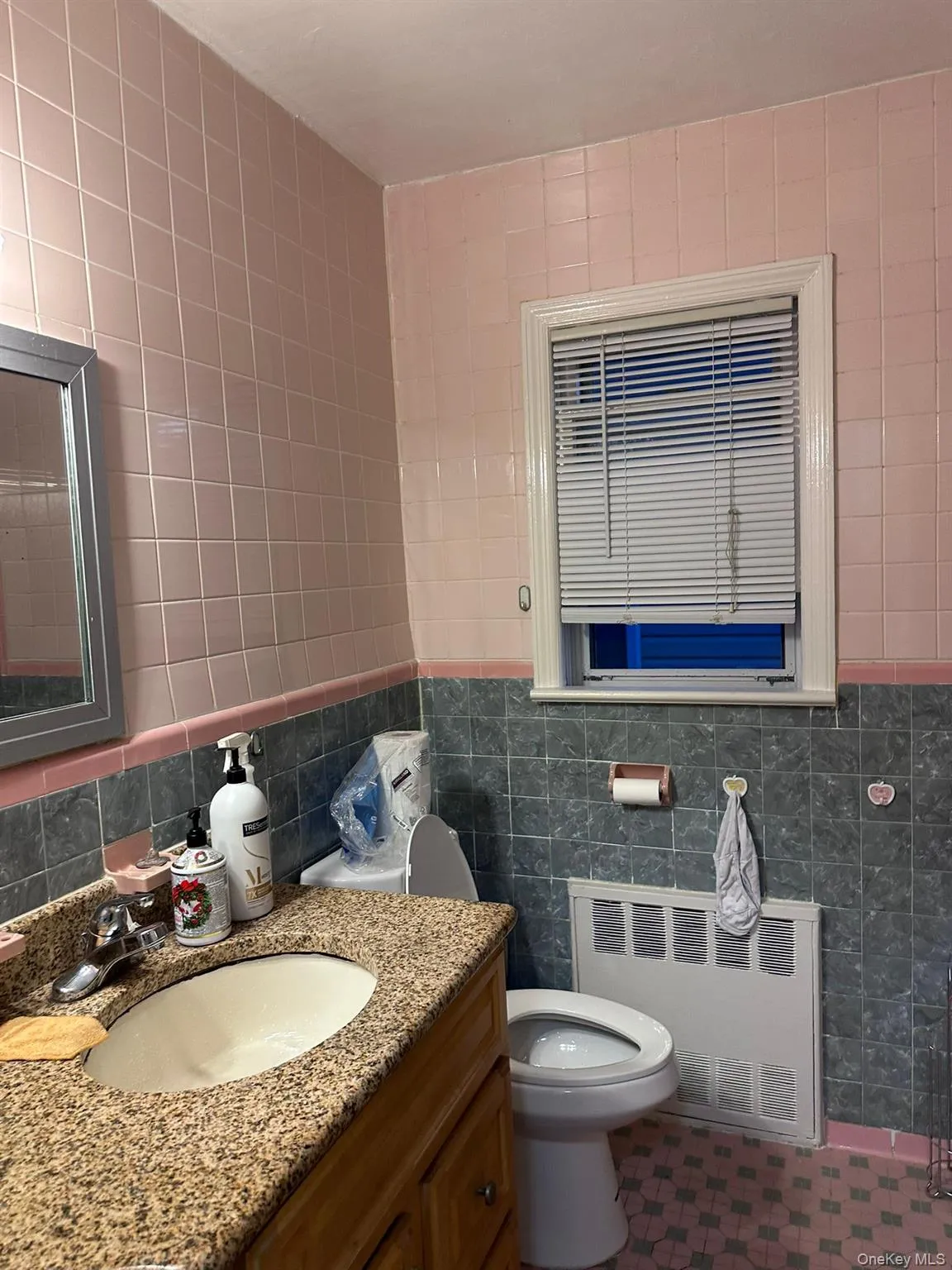 Bathroom featuring tile walls, vanity, and radiator Bathroom featuring tile walls, vanity, and radiator