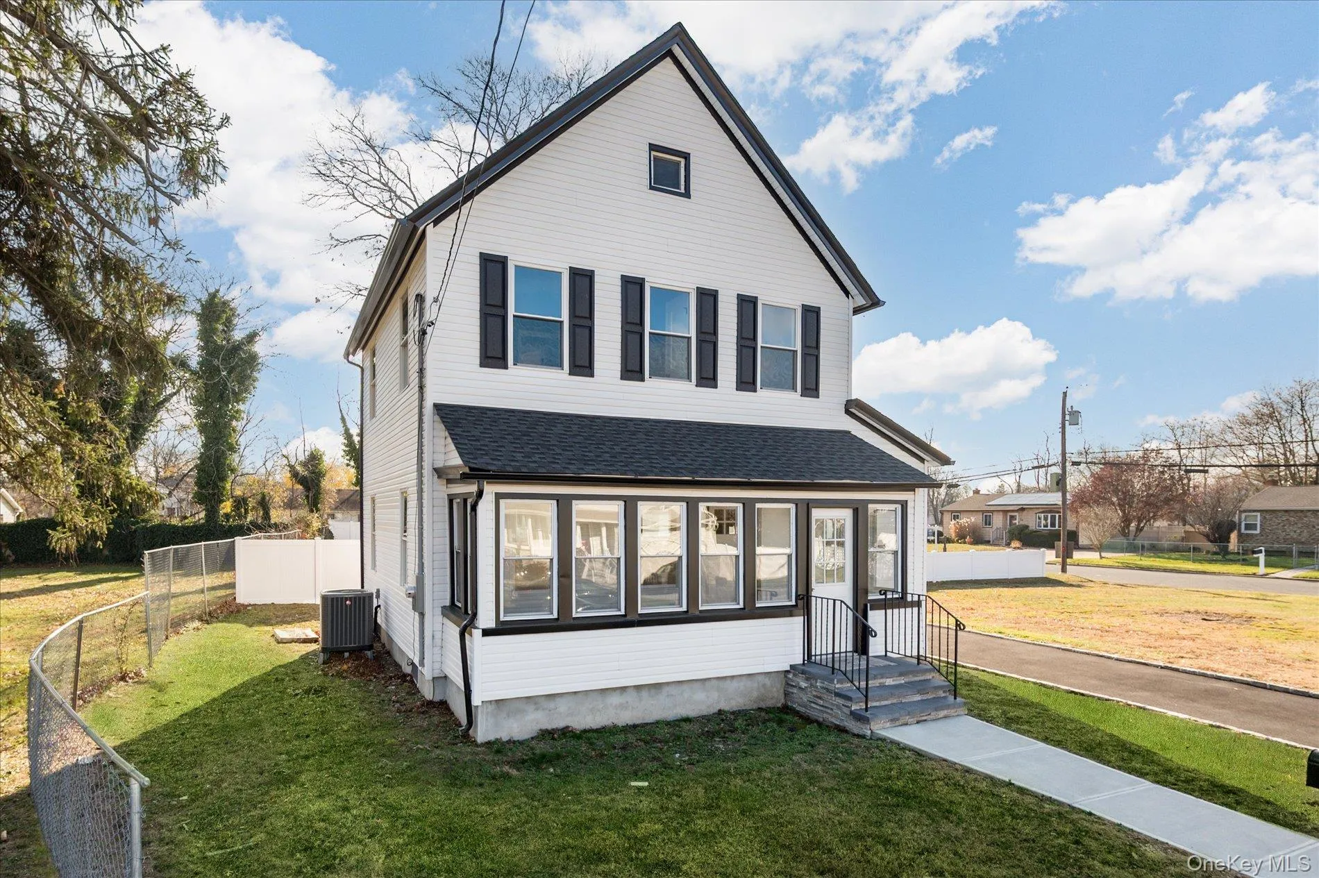 View of front of home with a sunroom and a shingled roof View of front of home with a sunroom and a shingled roof
