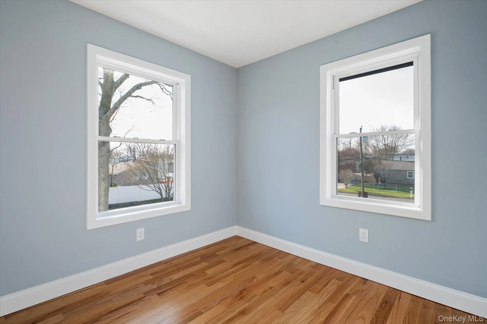 Unfurnished room featuring wood finished floors and baseboards Unfurnished room featuring wood finished floors and baseboards