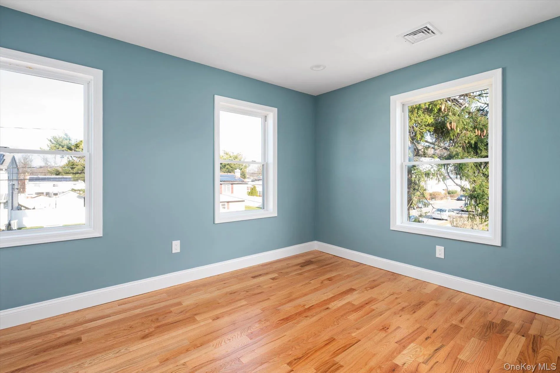 Empty room with wood finished floors and plenty of natural light Empty room with wood finished floors and plenty of natural light