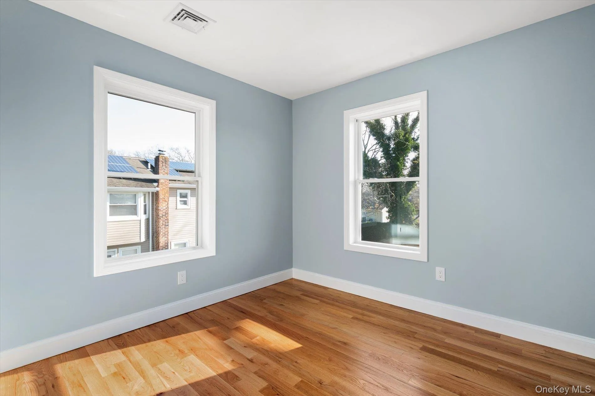 Spare room with baseboards and wood finished floors Spare room with baseboards and wood finished floors