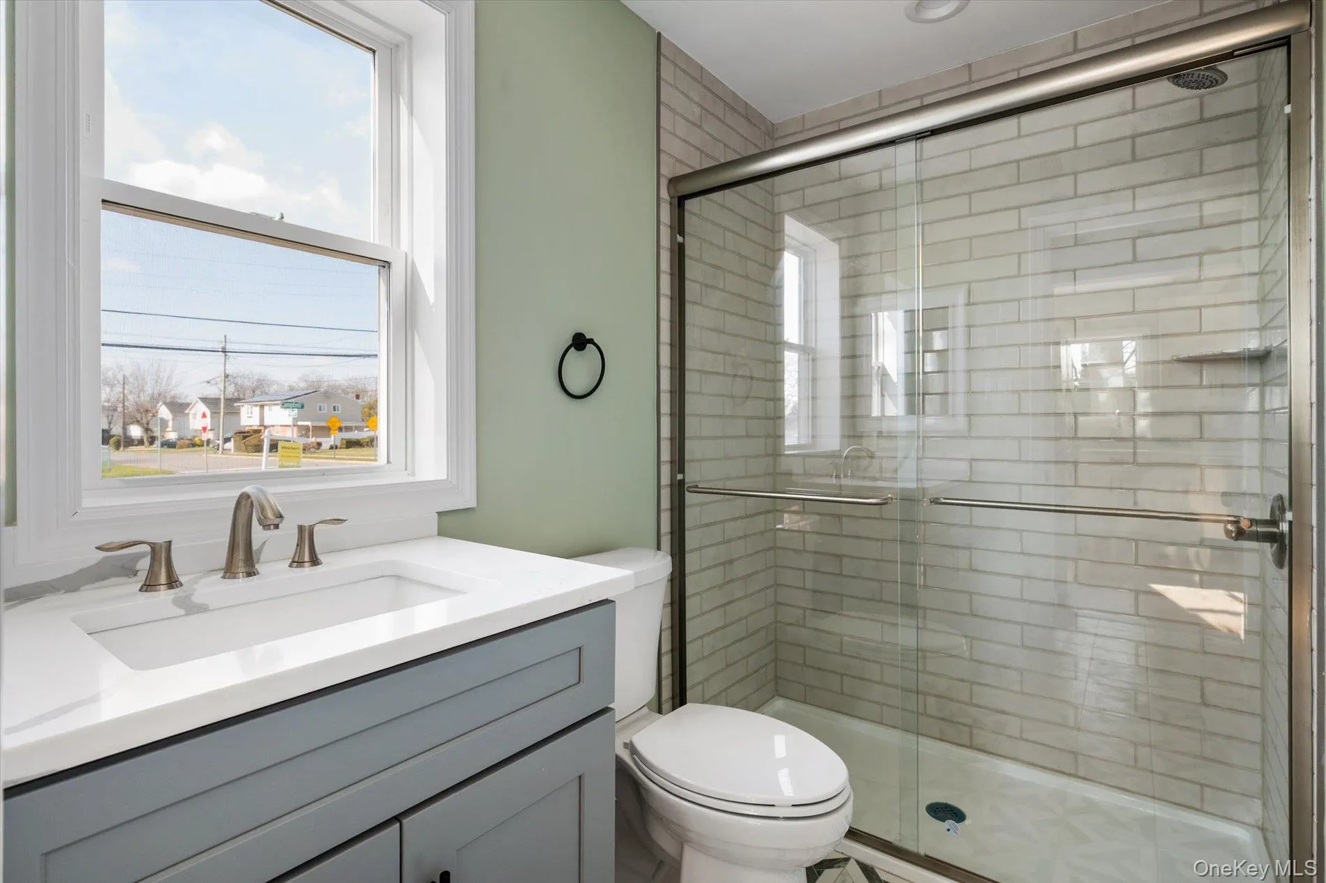 Bathroom featuring a shower stall and vanity Bathroom featuring a shower stall and vanity