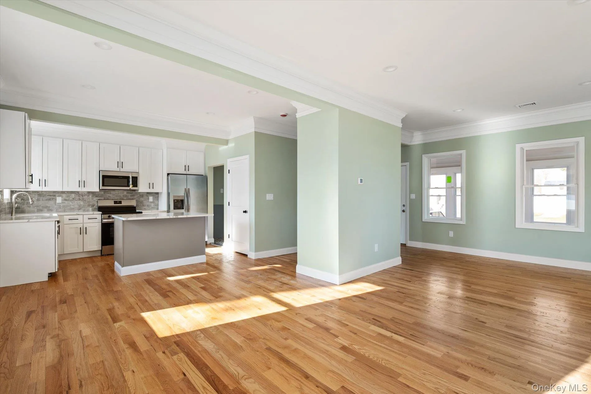 Unfurnished living room with crown molding, light wood finished floors, and recessed lighting Unfurnished living room with crown molding, light wood finished floors, and recessed lighting