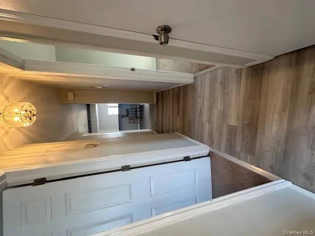 Corridor with light wood-style flooring and a chandelier Corridor with light wood-style flooring and a chandelier