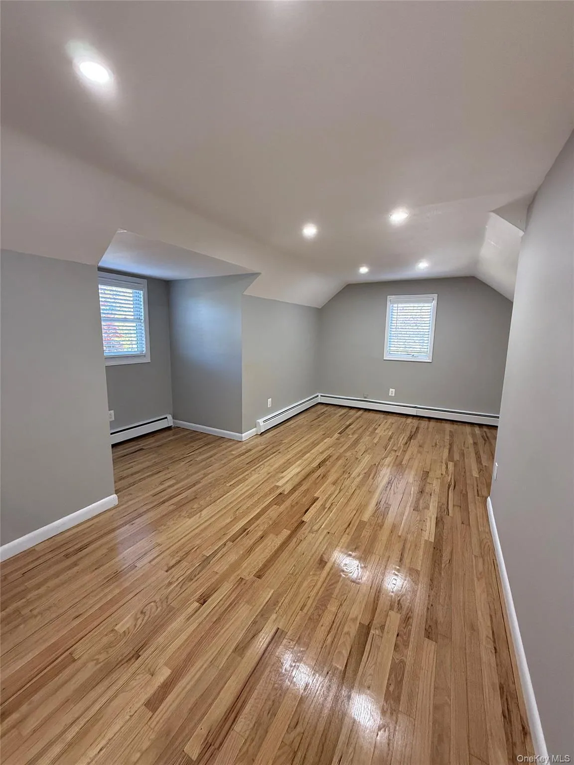 Bonus room featuring light wood-style flooring, recessed lighting, vaulted ceiling, and baseboard heating Bonus room featuring light wood-style flooring, recessed lighting, vaulted ceiling, and baseboard heating