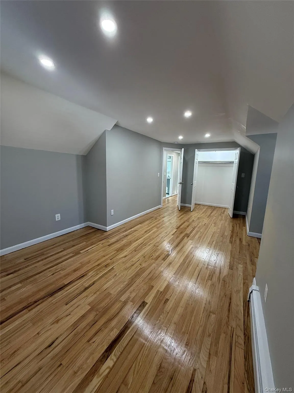 Additional living space featuring light wood-style floors, recessed lighting, and baseboard heating Additional living space featuring light wood-style floors, recessed lighting, and baseboard heating