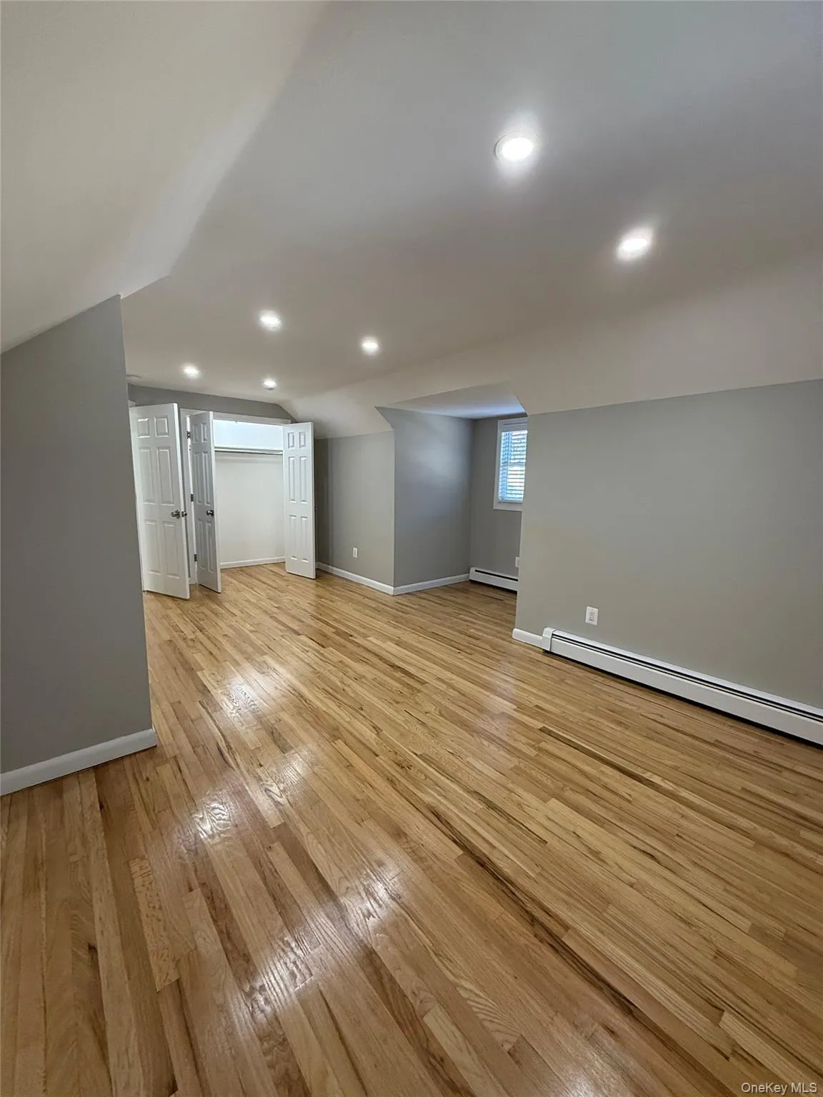 Below grade area featuring baseboard heating, light wood-style flooring, and recessed lighting Below grade area featuring baseboard heating, light wood-style flooring, and recessed lighting