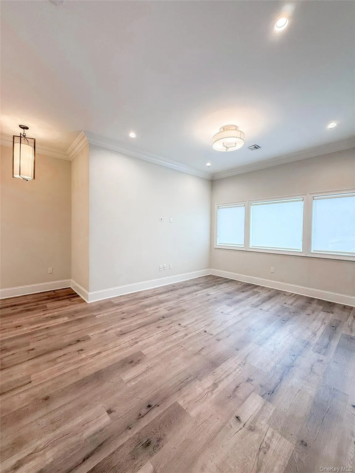 Empty room featuring ornamental molding, light wood-style floors, and recessed lighting Empty room featuring ornamental molding, light wood-style floors, and recessed lighting