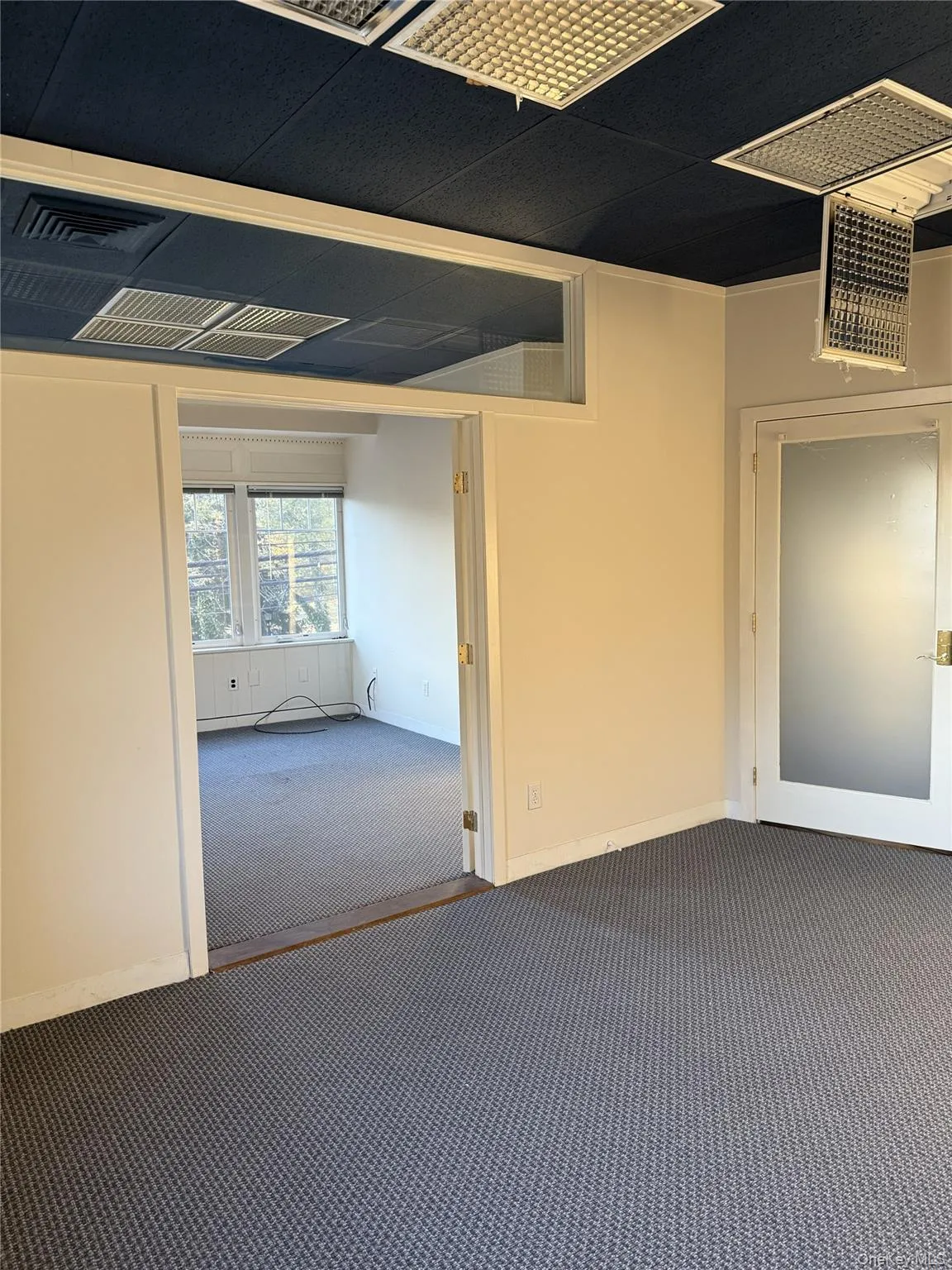 Empty room with dark carpet and baseboards Empty room with dark carpet and baseboards