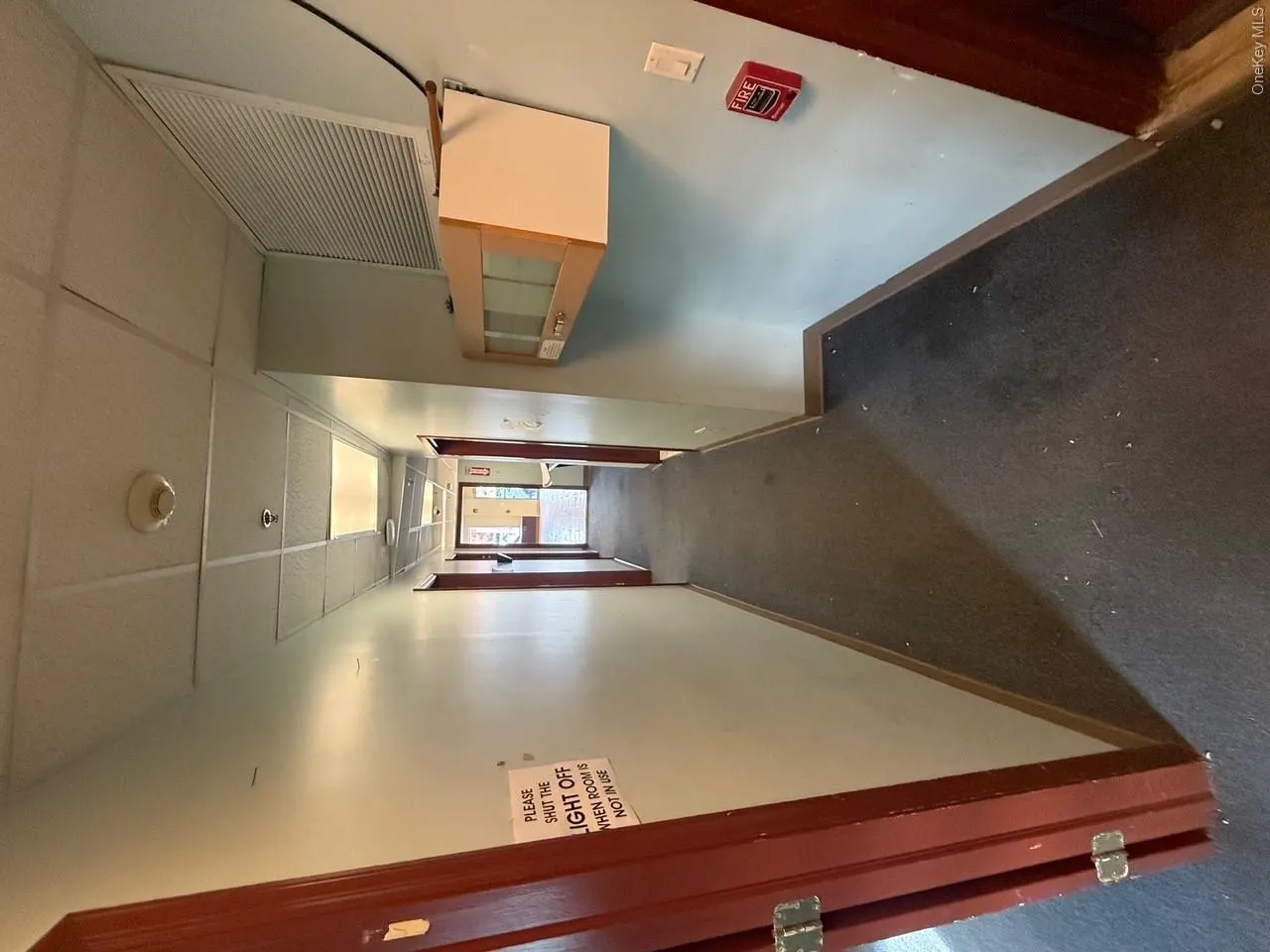 Corridor featuring a drop ceiling and carpet floors Corridor featuring a drop ceiling and carpet floors