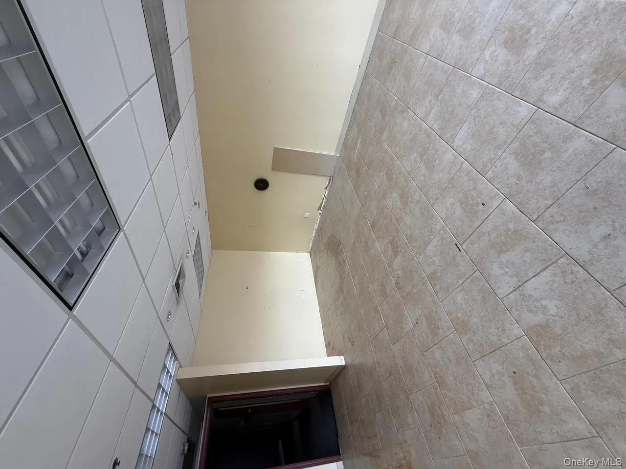 Unfurnished room featuring a paneled ceiling and light tile patterned floors Unfurnished room featuring a paneled ceiling and light tile patterned floors