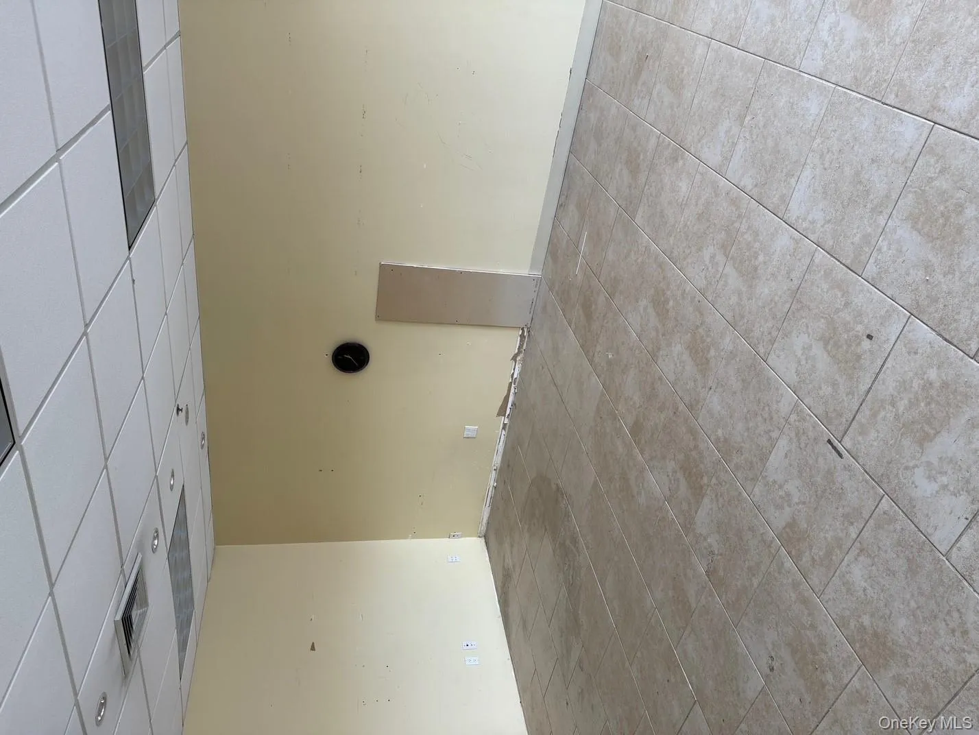 Tiled empty room featuring a drop ceiling and baseboards Tiled empty room featuring a drop ceiling and baseboards