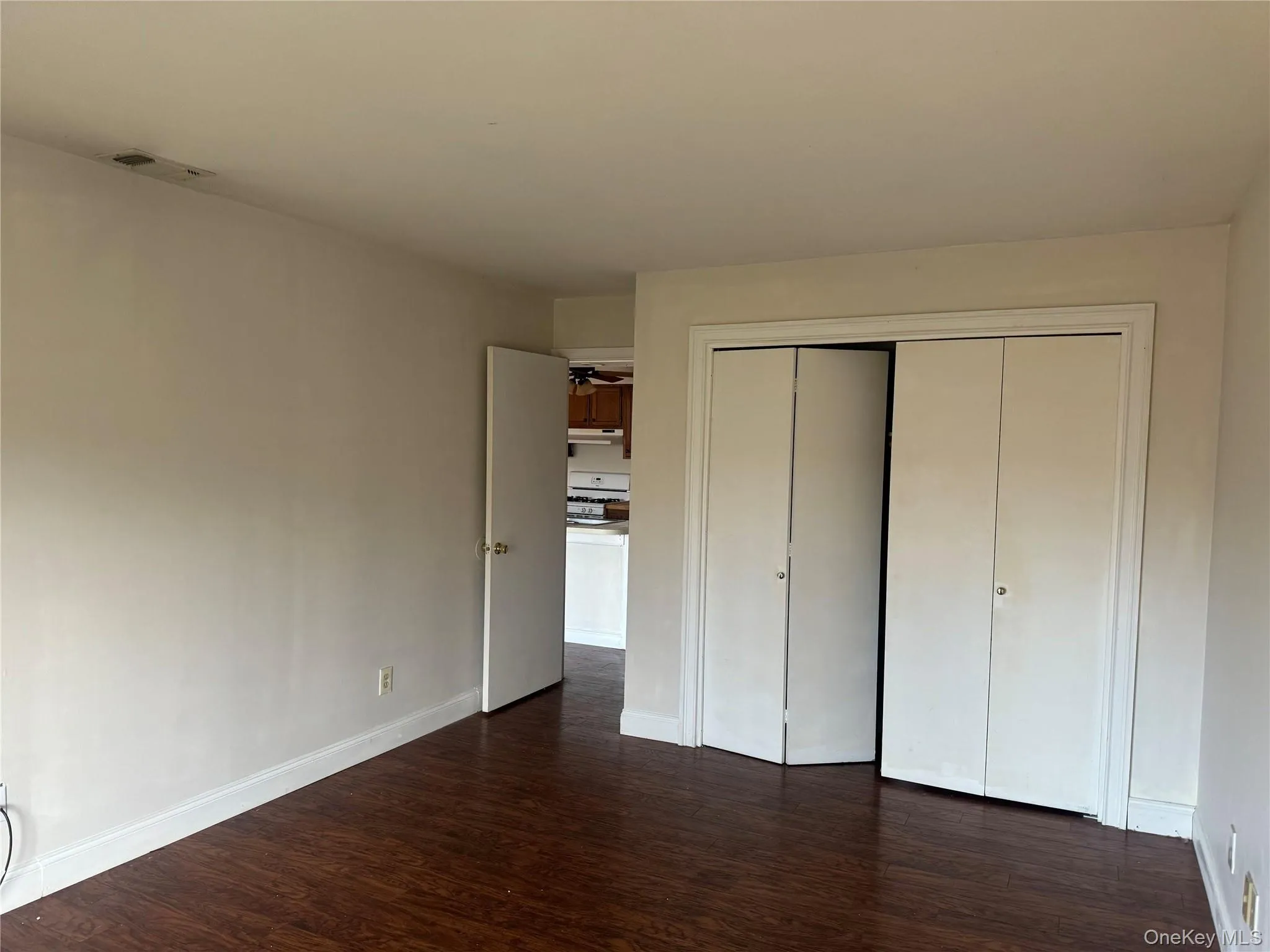 Unfurnished bedroom featuring dark wood-type flooring and a closet Unfurnished bedroom featuring dark wood-type flooring and a closet